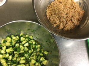 Soba noodles dressed with spicy sauce and cucumbers dressed with ginger, sesame dressing